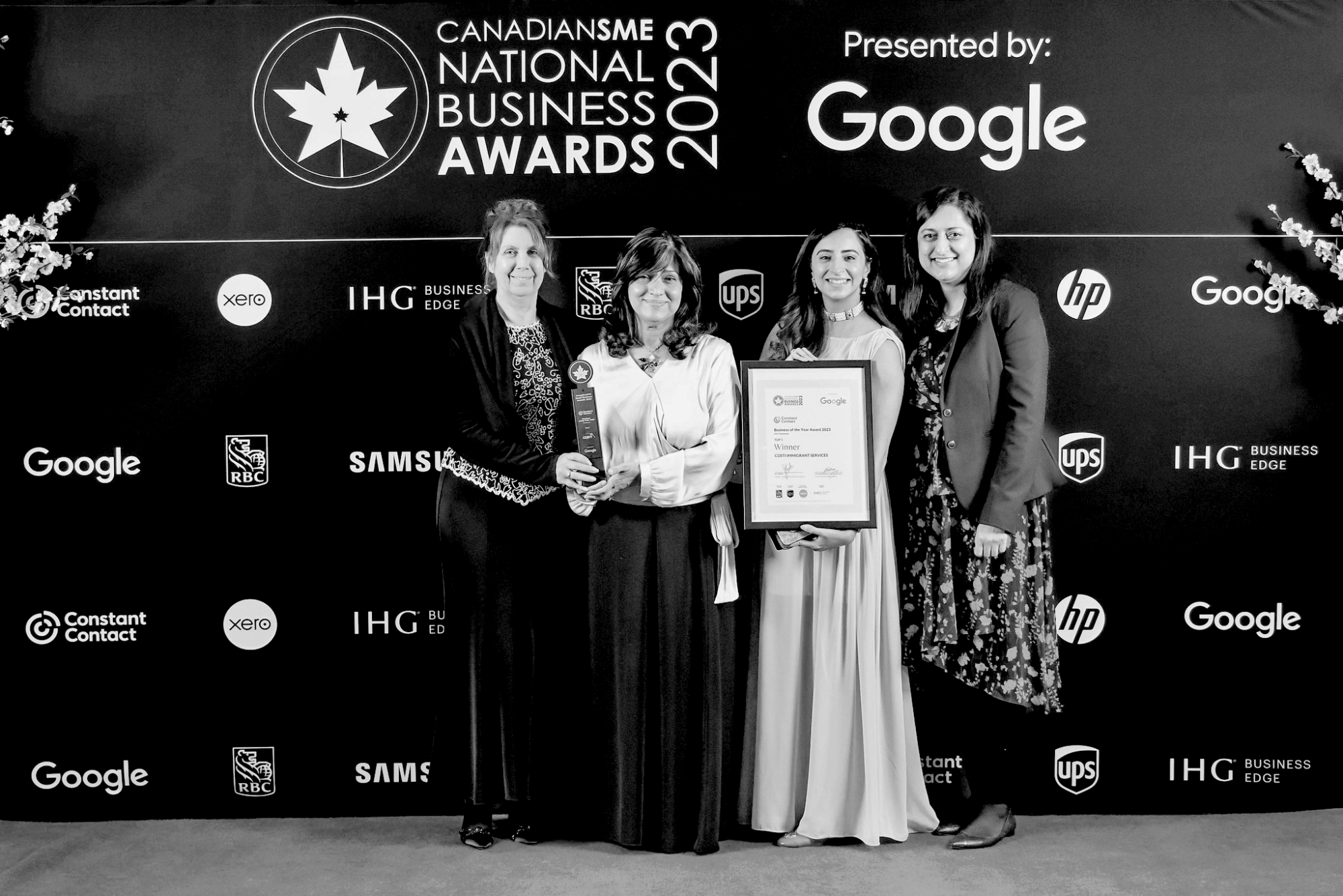 Senior Director Janet Hallett, CEO Samina Sami, Manager Communications and Events Anam Raheel and Senior Director People and Culture Robina Yasin are together holding a trophy and a laminated certificate, standing in front of an event backdrop that says, “CanadianSME National Business Awards 2023, presented by Google”