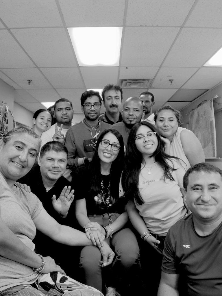 A diverse group of students smiling and posing together for a group photo in a classroom